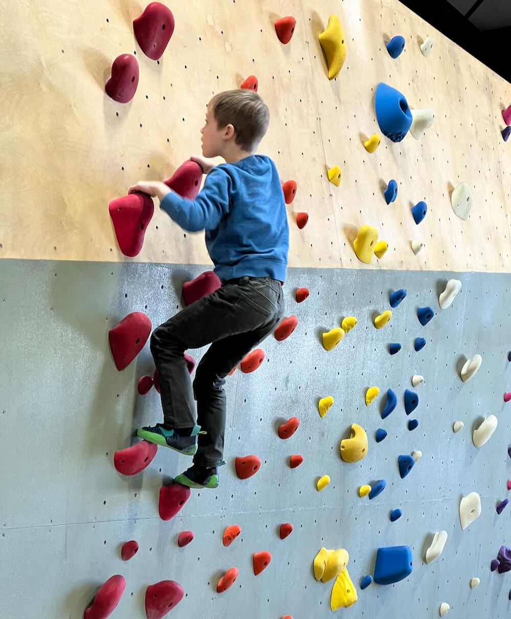 boy at rock climbing gym boy at rock climbing gym